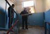 Мужчина достает часть снаряда из квартиры, разрушенной в результате обстрела Донецка.