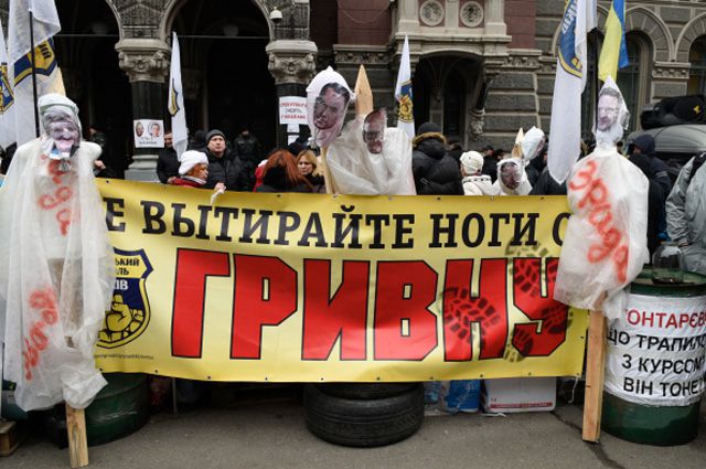 Участники акции протеста у здания Национального банка Украины в Киеве.