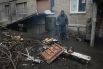 Житель Дебальцево готовит еду на костре у подъезда жилого многоквартирного дома, пострадавшего в результате обстрелов во время боевых действий.