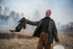 Житель Ново-Николаевского держит огонь под контролем с пустым ведром и мокрой тряпкой.