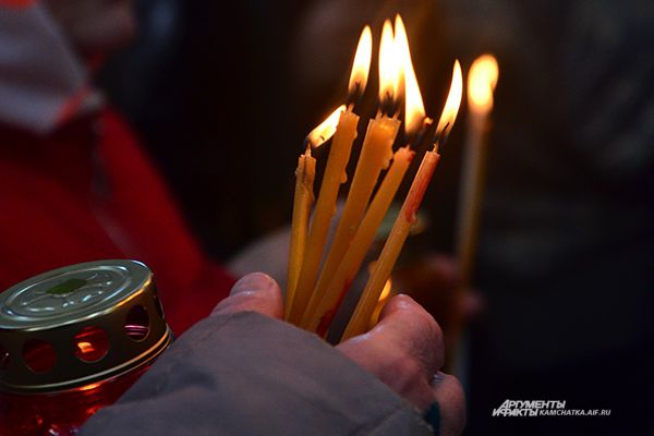 Верующие подносили к огню сразу по несколько свечей.