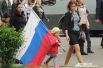 Маленькие дети с  удовольствием и гордостью несут в руках российский флаг.
