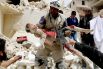 Солдат войск Гражданской обороны несет ребенка, погибшего при налете авиации режима Башар аль-Асада (Сирия).