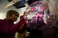 Дети играют с плазменным шаром в музее занимательных наук «Экспериментаниум» в Москве.
