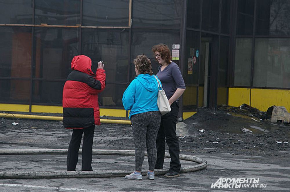 Работники магазинов, работавших в ТЦ утром собрались к месту пожара.
