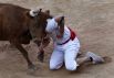 Испании, 10 июля. Участника фестиваля Сан-Фермин в Памплоне не смог убежать от быка.