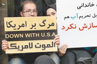 Иран прекращает ядерную программу, однако внешняя и внутренняя политика страны остаётся преж­­ней. Надпись на плакатах - «Долой США!». 