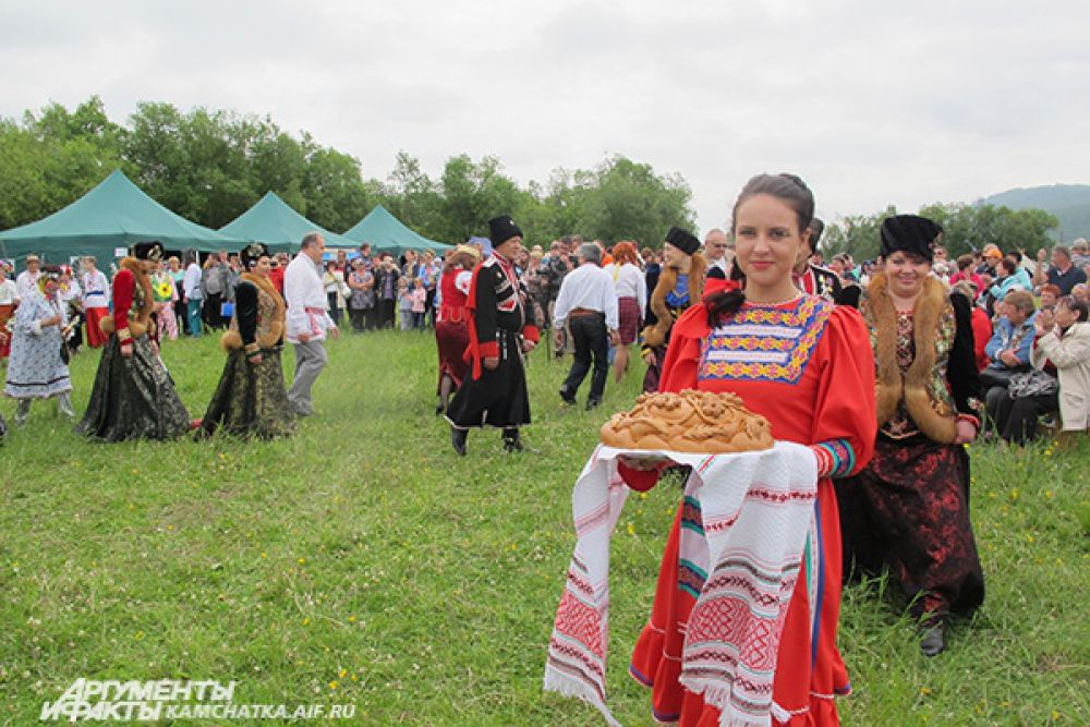 Славянская красавица угощала гостей праздника вкуснейшим белым хлебом.