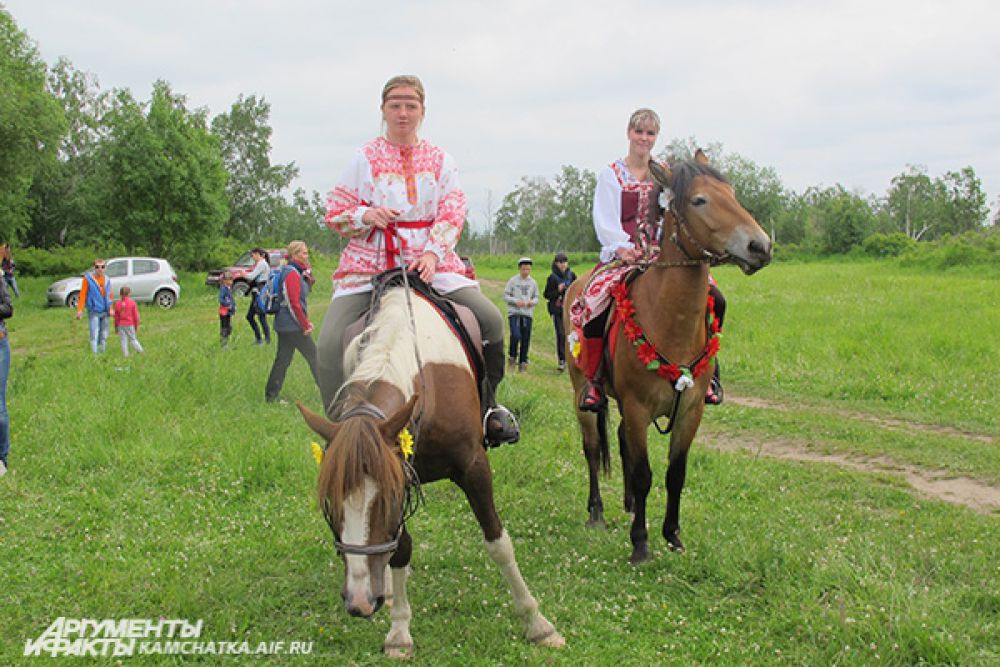 В расшитых платьях и рубашках, с лентами в косах восседали девушки на лошадях.