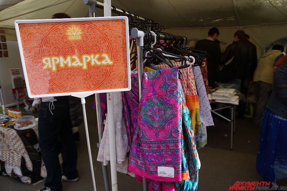 Ярмарка товаров с различными платьями и сувенирами.