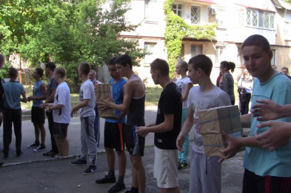 Украинские школьники разгружают книги, по которым уже завтра им придётся готовиться к выпускным экзаменам.
