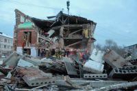 Сотрудники МЧС РФ разбирают завалы разрушенного взрывом дома в поселке Корфовский.