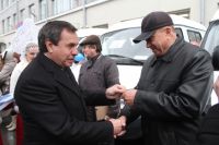 Владимир Городецкий вручает селянам ключи от автомобилей.
