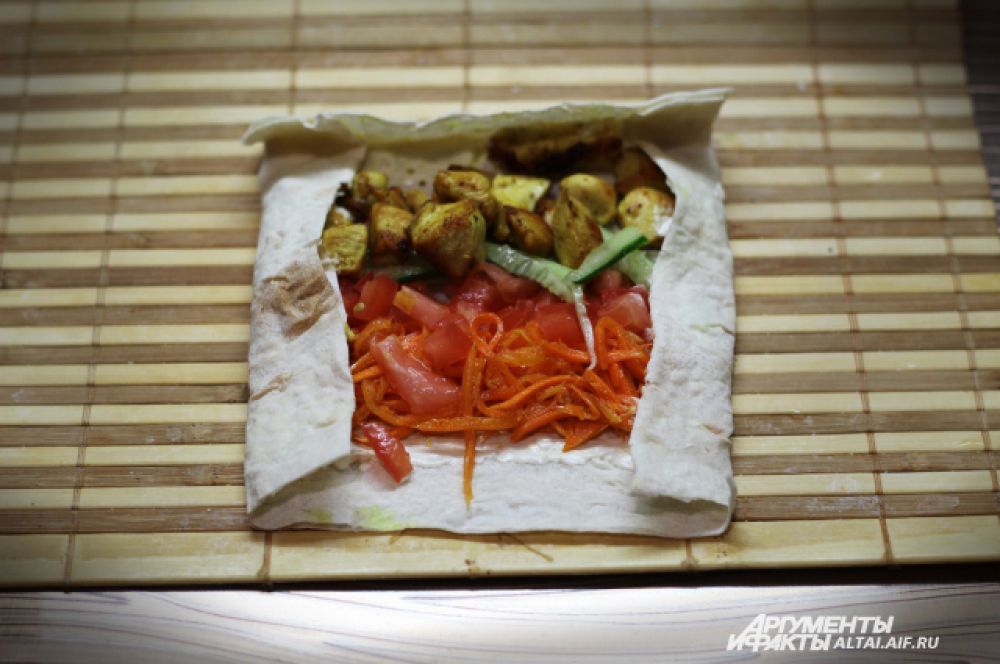 Далее рядками выкладываем овощи и мясо, совсем не много, так как шаурма у нас «мини». И заворачиваем края вовнутрь.