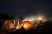 Лагерь беженцев. Люди пытаются согреться с помощью открытого огня рядом с палатками, Идомени.