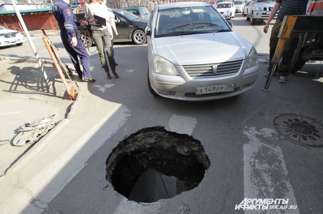 В Омске автомобиль провалился в яму в асфальте. 