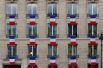 Французские флаги на жилом здании рядом с местом проведения церемонии.