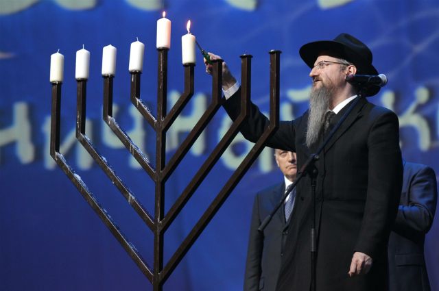 Главный раввин России Берл Лазар зажигает свечу.