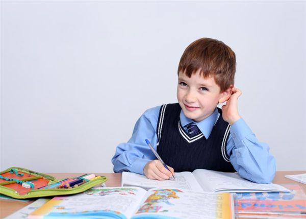 Школьный потратил. Мальчик сидящий за учебным столом фото.