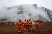 Работники пожарной службы на месте схода оползня в Китае.