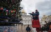 Рабочие украшают Новогоднюю ёлку на Соборной площади Кремля в Москве.