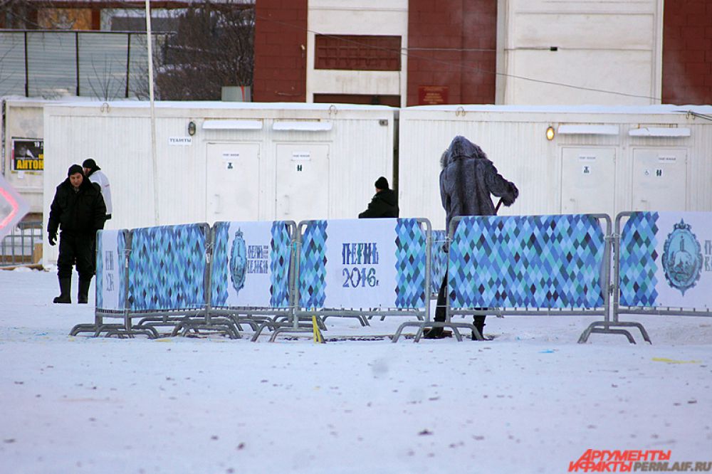 На эспланаде рабочий убирает мусор с ледового городка.
