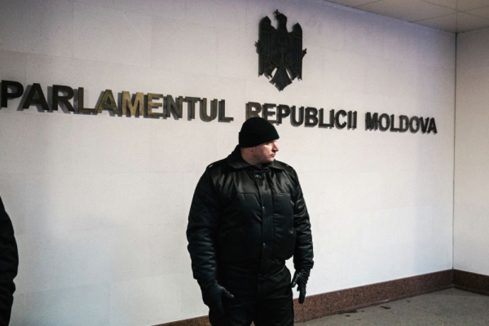 Сотрудник правоохранительных органов у здания парламента в Кишиневе. В среду парламент Молдавии утвердил новый состав кабинета министров во главе с Павлом Филипом.