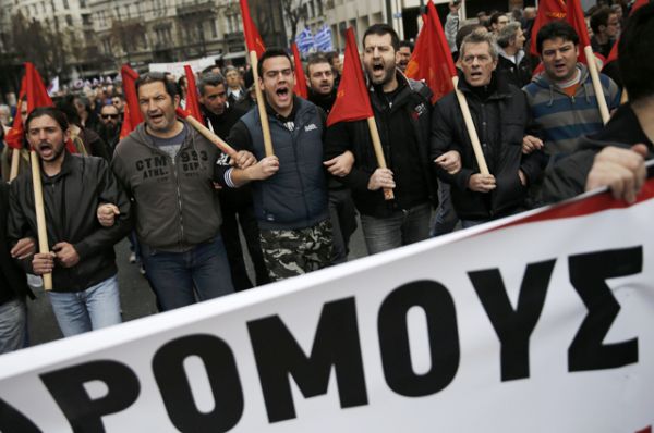 Демонстранты на марше во время 24-часовой всеобщей забастовки против запланированных пенсионных реформ в Афинах, Греция.
