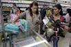 Женщина предъявляет свою идентификационную карточку и свидетельство о рождении ребенка, чтобы купить подгузники и мыло в супермаркете.