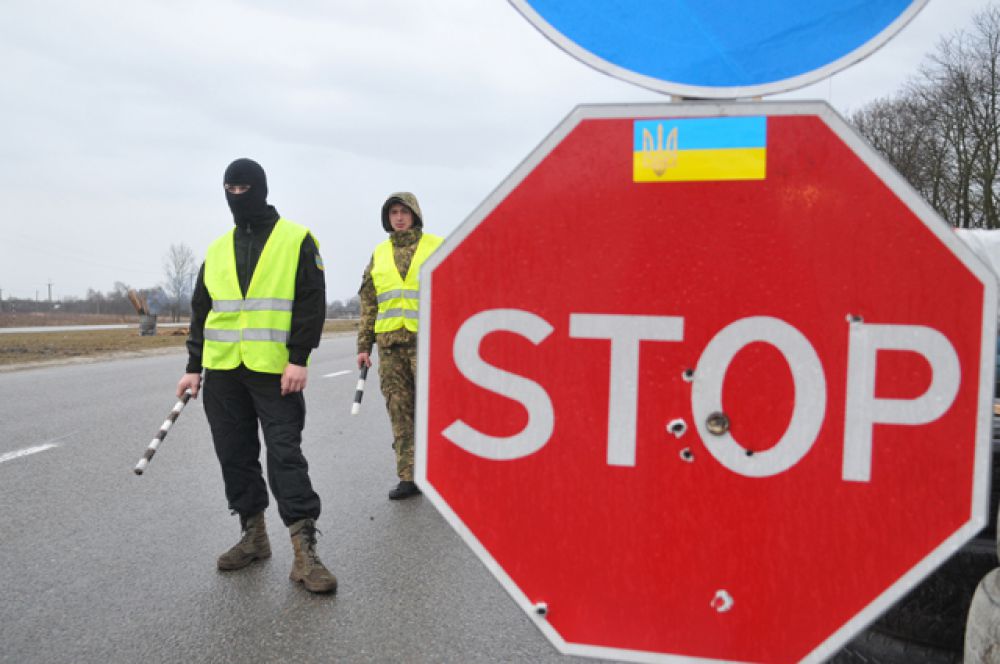Украинские активисты стоят на блокпосту возле Львова, блокируя движение грузовиков с российскими номерами во Львовской области.
