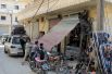 Жители ремонтируют поврежденный магазин в городе Дарат Изза на северо-западе Алеппо.