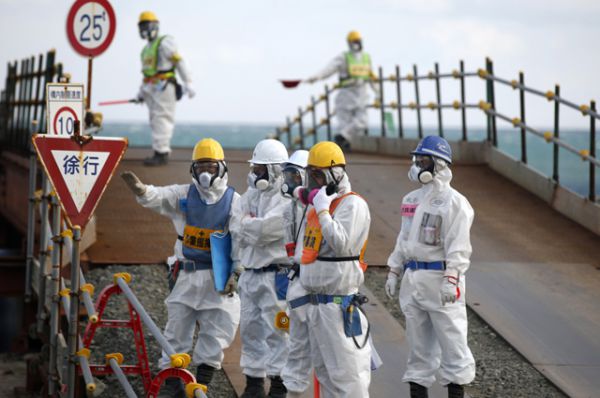 Рабочие в защитных костюмах и масках на АЭС Фукусима-1, март 2016 года.
