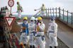 Рабочие в защитных костюмах и масках на АЭС Фукусима-1, март 2016 года.