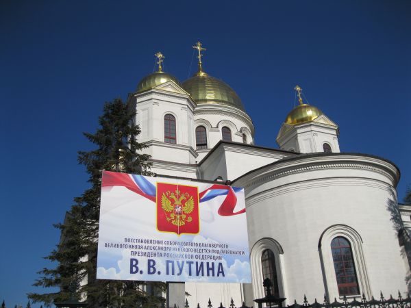 Колонна проходит мимо Александро-Невского собора, восстановление которого ведется под патронатом президента РФ Владимира Путина 