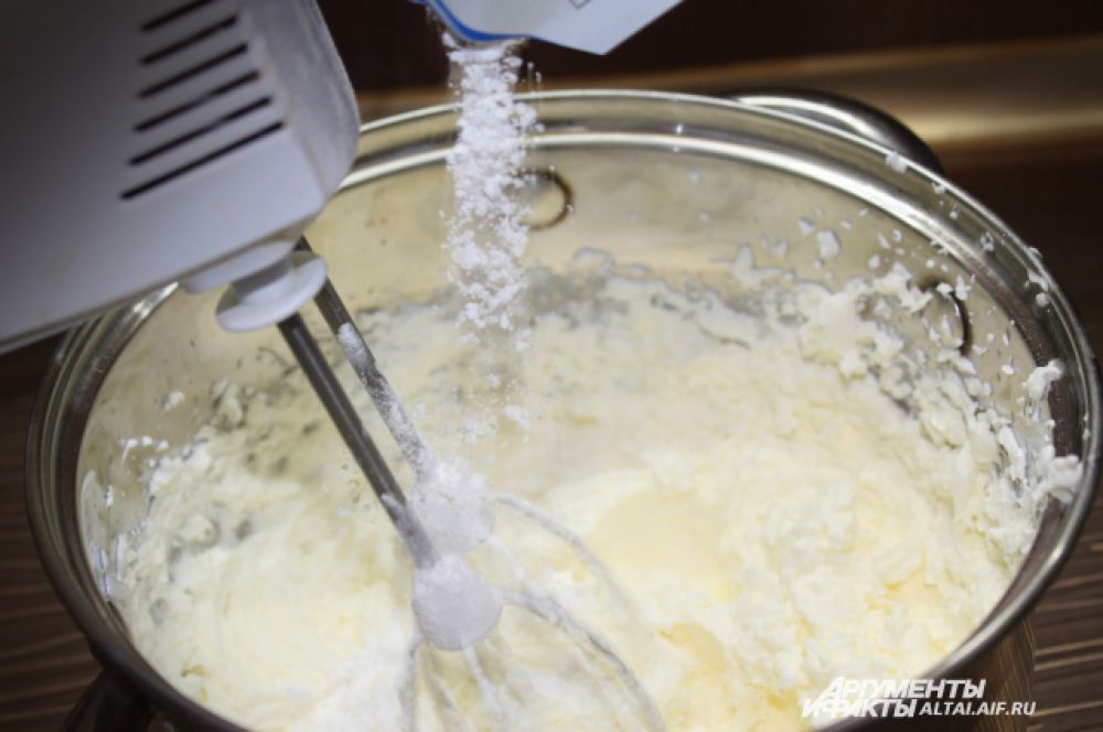 Когда сливки загустели, не переставая взбивать, вводим сахарную пудру тонкой струйкой. 