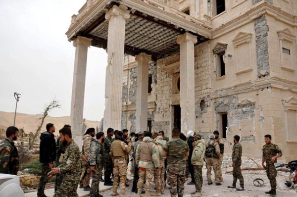 Бойцы сирийской армии рядом с дворцовым комплексом на западной окраине Пальмиры.