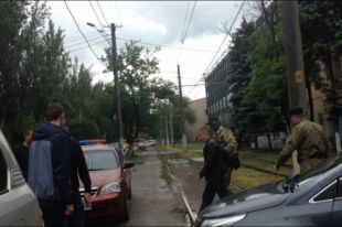 Задержанного капитана полиции ведет в служебное авто