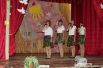 В сельском клубе Русского школьники своими силами поздравляют бывших пограничников. Они исполнили песни о пограничнике. Сцена украшена словами «С Днем пограничника!».