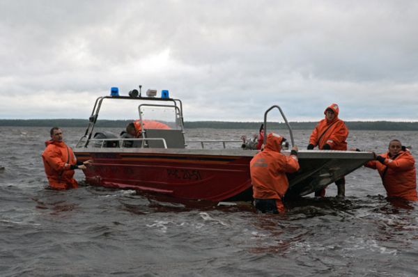 Спасатели спускают лодку на воду на месте проведения поисково-спасательной операции в районе озера Сямозеро в Карелии, на котором в туристическом походе во время шторма погибли дети.
