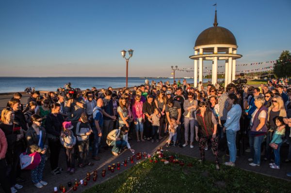 Люди на набережной в Петрозаводске во время акции в память о детях, погибших при шторме на Сямозере в Карелии.