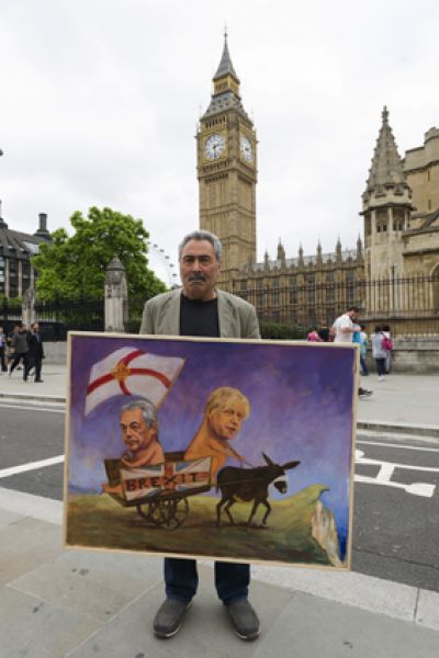 Мужчина с агитационным плакатом на улице Лондона перед предстоящим референдумом.