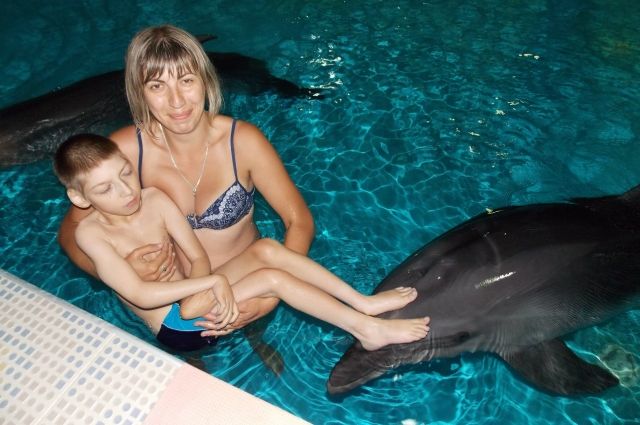 Для того чтобы работала голова и мышцы ребёнка, ему необходимо постоянно проходить реабилитацию. В том числе - дельфинотерапию.
