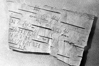 Берестяная грамота, принадлежавшая ребенку. На ней нацарапаны буквы древнерусского алфавита. Слева рисунок. 