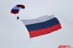 Парашютисты пролетели над зрителями с флагом России.