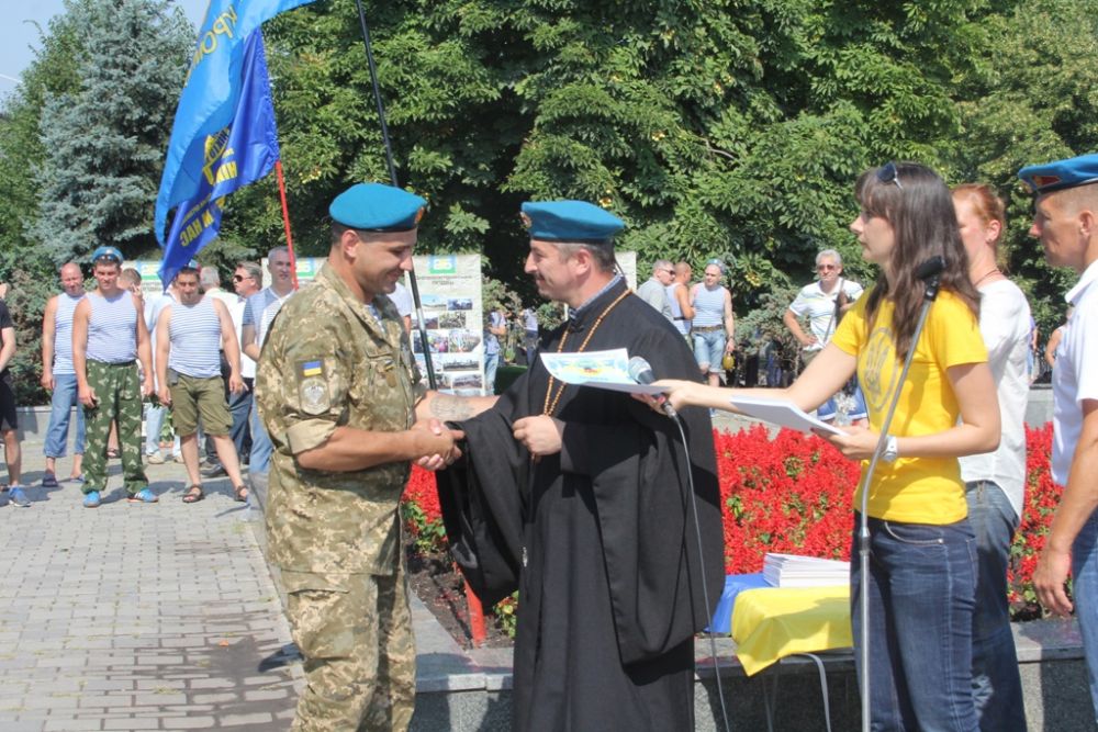 Вот капеллан вручает награду десантнику