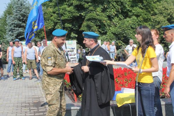 Вот капеллан вручает награду десантнику