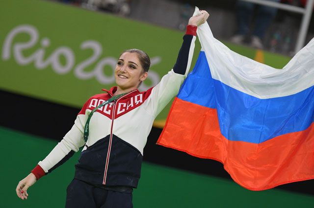Алия Мустафина (Россия), завоевавшая золотую медаль в упражнениях на брусьях на соревнованиях по спортивной гимнастике среди женщин на XXXI летних Олимпийских играх, на церемонии награждения.