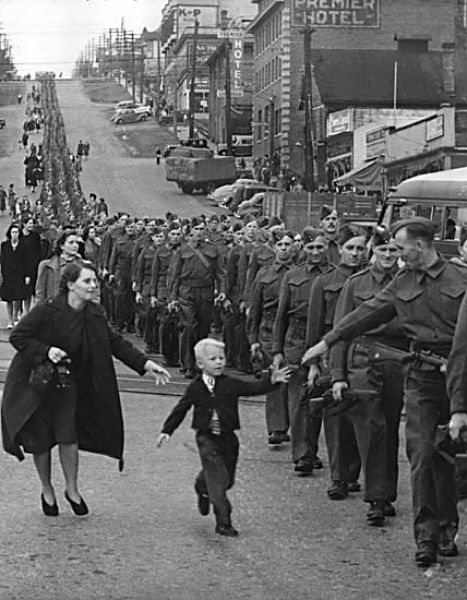 «Подожди меня, папа» — фотография марша полка Британской Колумбии в Нью-Уэстминстере в Канаде, сделанная Клодом П. Деттлоффом 1 октября 1940 года. Пока Клод делал снимок, пятилетний Уоррен Бернард убежал от своей матери к отцу, рядовому Джеку Бернару, с криком «Подожди меня, папа». 