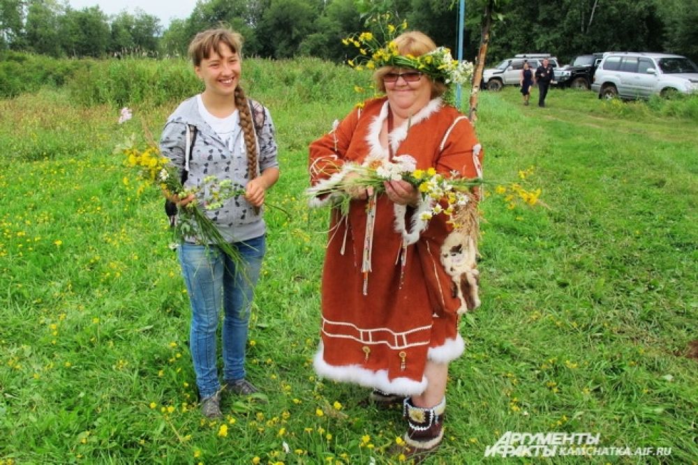 Девушки и женщины плели венки из полевых цветков на конкурс.