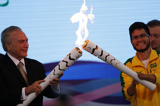И. о. президента Бразилии Мишел Темер (слева) зажигает огонь Паралимпиады.